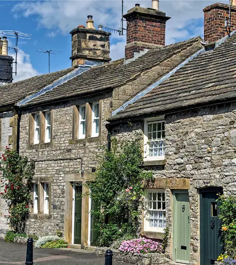 Ashford: cottage in pietra con fiori lungo una strada