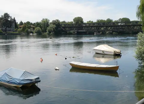 Sesto Calende: barche ormeggiate sul Ticino, con il ponte di ferro e gli alberi sulla riva opposta