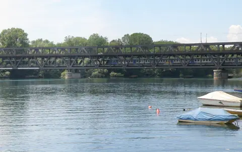Sesto Calende: il ponte di ferro a due piani sul Ticino, con un treno in transito e barche sull’acqua