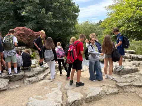 Gruppo di ragazzi sulle rocce di un giardino, tra alberi e aceri rossi