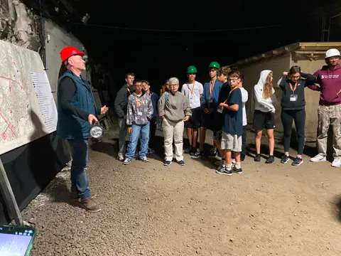 Ragazzi con caschetti colorati durante una visita guidata in una galleria sotterranea