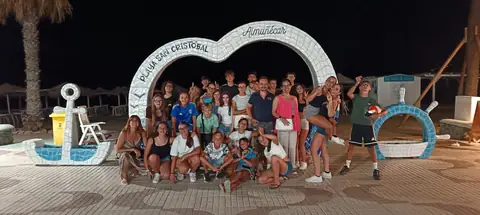 Foto di gruppo di sera sotto l’arco a forma di cuore della Playa San Cristóbal di Almuñécar